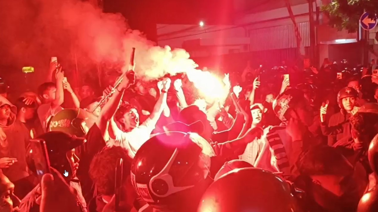 Ribuan suporter Persikmania menyalakan flare saat menyambut kedatangan tim Persik Kediri di mess pemain, Senin dini hari.